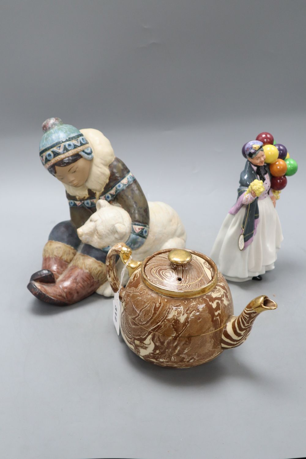 A Lladro stoneware group, a Doulton figure Biddy Penny Farthing HN1843 and a marbleware teapot